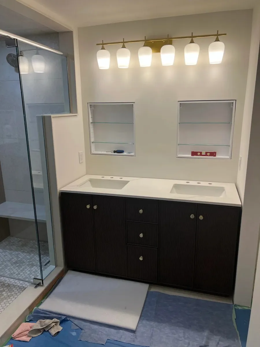 Bathroom vanity after renovation with updated cabinetry and lighting